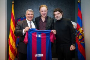 Photograph of Juan Laporta (FC Barcelona President), Neo Sala (FEAT founding director and founder and CEO of Doctor Music), and Juli Guiu (FC Barcelona Vice President) holding a football shirt