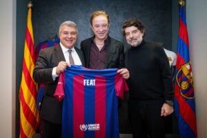 Photograph of Juan Laporta (FC Barcelona President), Neo Sala (FEAT founding director and founder and CEO of Doctor Music), and Juli Guiu (FC Barcelona Vice President) holding a football shirt
